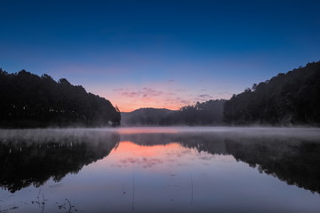 sunrise at Pang Oung, lake view morning beautiful scenic of pine forest with reflection on the surface of water with soft mist moving on the water, Pang Oung reservoir, Mae Hong Son, northern Thailand