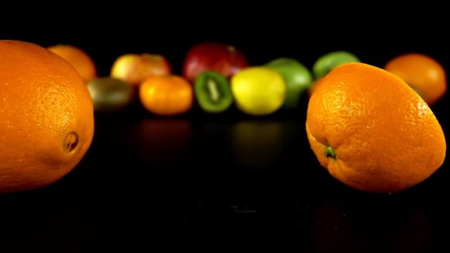 Falling of orange against the background of fruit. Slow motion.
