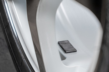 A fragment of the wheel of a car with a balancing weight