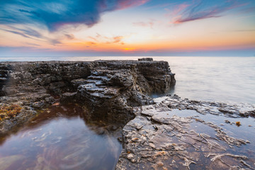 Enjoying the colorful sunset on a beach with rocks on the Adriatic Sea coast Istria Croatia