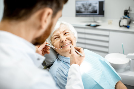 Elderly woman during the medical examination with male dentist in the dental office