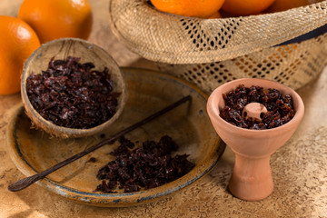 Hookah in a clay bowl for Smoking hookah with persimmon fruit in the background.