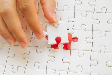Hand putting the last piece of jigsaw puzzle.Concept of solving problem