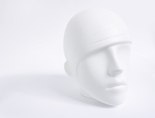 White plastic human head from mannequin as soft object with shadows, shades of gray, mild style concept, on white