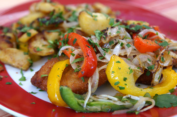 Schnitzel (German escalope) with fried peppers, onions and potatoes