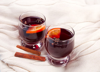 Two wineglass with Christmas mulled red wine with spices and fruits on a wooden rustic table.