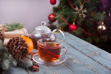 Cup of tea and teapot on a wooden background. Christmas background.