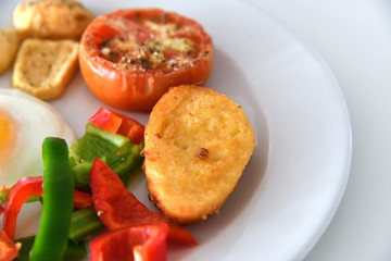 Breakfast with scrambled eggs, fried buns and vegetables