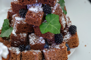 a cake of slices of baked pie with chocolate folded into each other in the form of a pyramid or fir tree. Festive Candy Bar at the Wedding. Selective focus