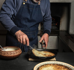 turning a hot pancake with a crispy crust with a metal spatula