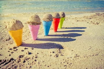 Colorful sand cones in the sand on the beach,summer concept,used split toning for vintage style.