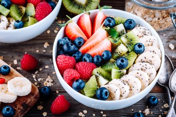 Healthy breakfast bowl granola with  raspberries, strawberries, blueberries, banana, kiwi and chia seeds