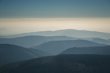 Distant mountain range and thin layer of clouds on the valleys.