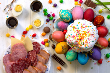 Festive composition in rustic style, Easter meal Breakfast. Easter cake and painted eggs on white wooden table. Top view flat lay background.