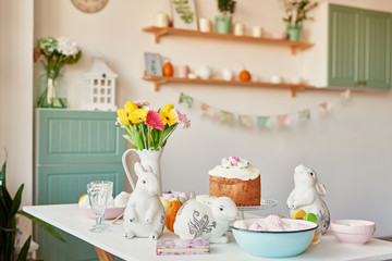 Easter sweet bread, Easter cake and multi-colored eggs with tulips and a white rabbit. Holidays breakfast concept with copy space. Retro style in tones. Easter greeting card template