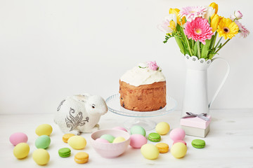 Easter sweet bread, Easter cake and multi-colored eggs with tulips and a white rabbit. Holidays breakfast concept with copy space. Retro style in tones. Easter greeting card template