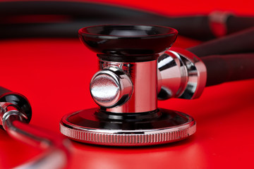 Stethoscope, close-up, red background