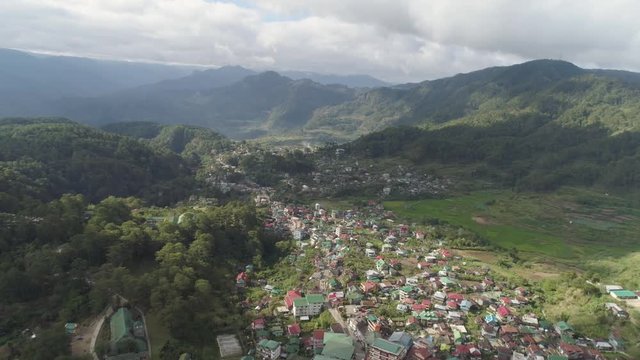 Aerial view town Sagada, located in mountainous province of Philippines. City in valley among mountains covered with forest.