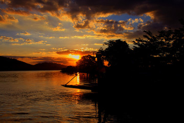 Naklejka na ściany i meble sunset on the lake Fishermen Twilight signals Coconut tree at sunset Beach showers