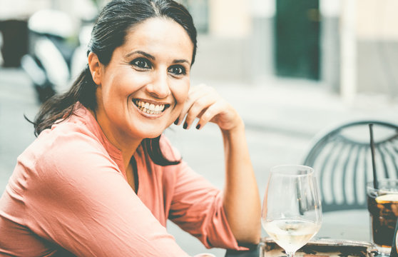 Portrait of a beauty italian mature brunette woman smiling in an outdoor cafe