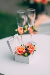 Two wedding glasses and bridal bouquet on stone in summer garden