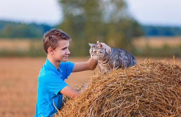 Teenager on a walk in the field with a British cat