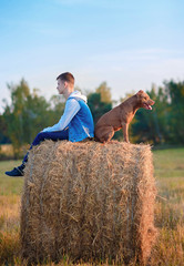 Young owner with a dog for a walk in the field