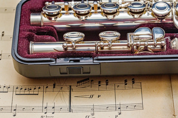 Naklejka premium Silver flute on classic sheet muisc