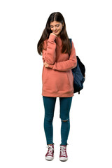 A full-length shot of a Teenager girl with sweatshirt and backpack looking down with the hand on the chin