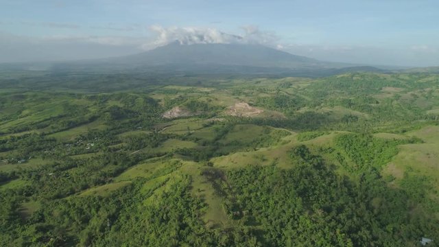 Aerial view mountain valley with hills covered forest, trees, mount Iriga. Luzon, Philippines. Slopes of mountains with evergreen vegetation. Mountainous tropical landscape.