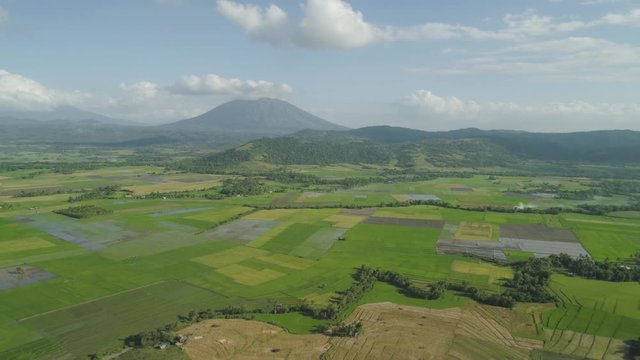 Mountain valley with farmland, rice terraces near mount Iriga. Aerial view mount with green tropical rainforest, trees, jungle with sky. Philippines, Luzon. Tropical landscape