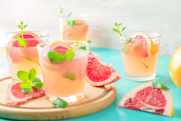 Pink alcoholic cocktail with grapefruit, ice and min