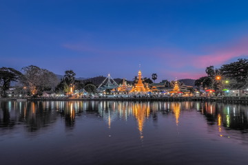 Fototapeta na wymiar Lake view evening of Wat Chong Klang and Wat Chong Kham Chedi Myanmar style art with reflection on the surface of water and colorful twilight vivid sky background, Mae Hong Son, northern of Thailand.