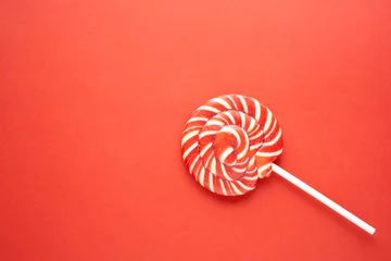 Selbstklebende Fototapete Süßigkeiten Creative concept photo of lolli pop popsicle candy on red background.
