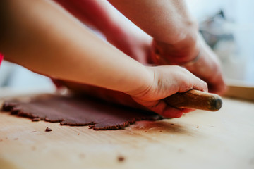 Help children during baking and cooking. The child helps to prepare the dough for baking. Baking cookies, family baking together. Flooding, making cookies. The concept of cooking.