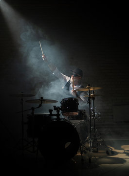 The old drummer raised his hand in a beam of light