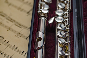 Fototapeta premium Close up of silver plated flute in its case on sheet music