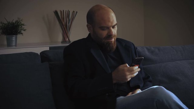 handsome Business man recording a business vocal message sitting on sofa