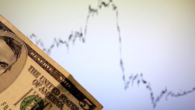 Crisis. Depreciation. Play on the stock exchange, currency markets and Forex. Graph analysis.  Analyst of the currency pair Euro and the dollar. Five dollar bill. The fall or growth of the dollar