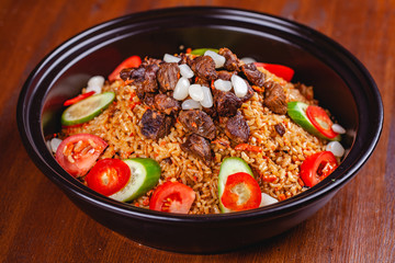 Traditional uzbek pilaf with meat, vegetables and garlic. Close up