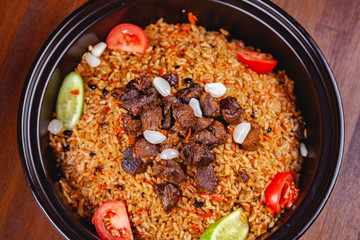 Traditional uzbek pilaf with meat, vegetables and garlic. Top view. Close up