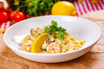 Italian pasta with seafood on white plate. Close up