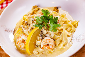 Italian pasta with seafood on white plate. Close up