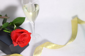 赤い薔薇の花とシャンパングラスと金色のリボン(白背景)