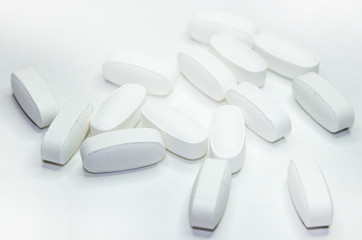 white medical pills, on white background, close-up