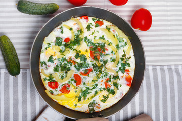 Traditional rustic omelette with bacon, pasta and greens .  Copy space