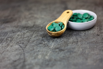 Spirulina in pills on dark background
