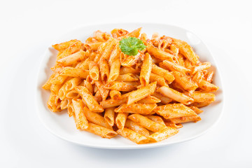 Penne with pesto decorated with parsley on a plate on a white background