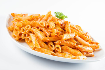 Penne with pesto decorated with parsley on a plate on a white background