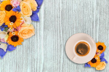 Fototapeta na wymiar Cup of morning coffee and fresh flowers on light wooden table. Place for text